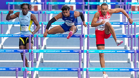 India's Tejas Shirse, centre, Saint Lucia's Khailan Vitalis, left, and others compete in the men's 110m hurdles round 1 heat 1 athletics at the 23rd Commonwealth Games, in Glasgow, Scotland, Monday.
