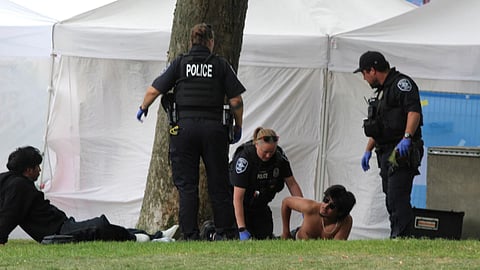 Police attend to a person after a shooting at Seattle Center during the Bite of Seattle food festival in Seattle, Washington.