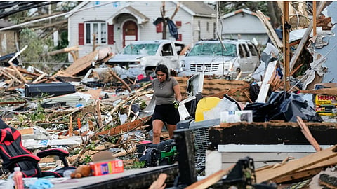 A woman walks among debris after a tornado struck in Menasha, Wis.