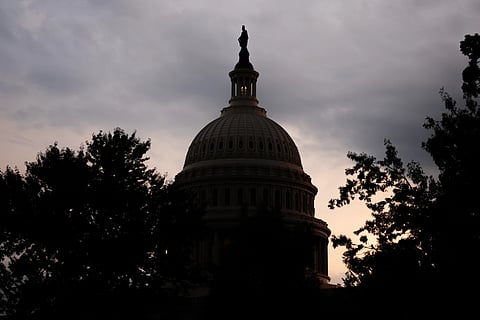 The sun sets behind the U.S. Capitol, Tuesday, July 28, 2026, in Washington.