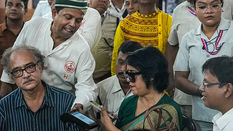 Exiled Bangladeshi author Taslima Nasrin attempts to make a digital payment during her visit to the historic College Street Coffee House, in Kolkata