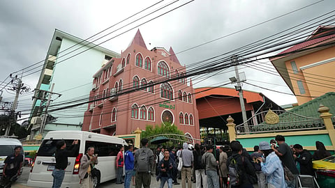 A crowd gathers outside a school where deaths and injuries were reported after a shooting in Thailand's Nonthaburi province