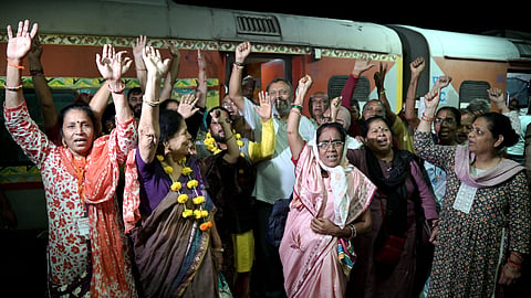 Stranded pilgrims from Nagpur who were rescued from flood-hit Nepal reach the Nagpur railway station early morning, in Nagpur, Maharashtra, Sunday