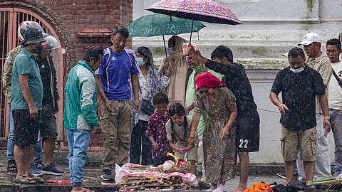Family members perform rituals amid rain during symbolic funerals of their loved ones, who are flood victims still reported missing, in accordance with Nepali Hindu rites, at Pashupatinath temple in Kathmandu