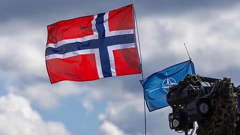 Norway's, left, and NATO's flags are seen during a military exercise 'Iron Wolf 2025-1' at the Gaiziunai Training Area, Lithuania.
