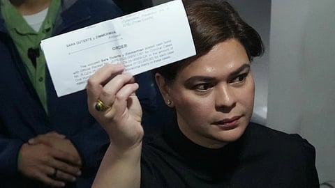Philippine Vice President Sara Duterte shows a document to reporters at the Quezon city justice hall
