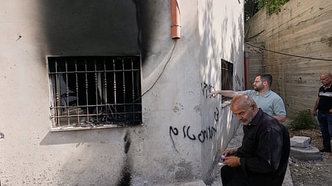 Palestinians check the damage to a mosque that, according to residents, was burned during an attack by Israeli settlers, in the West Bank village of Bazariya
