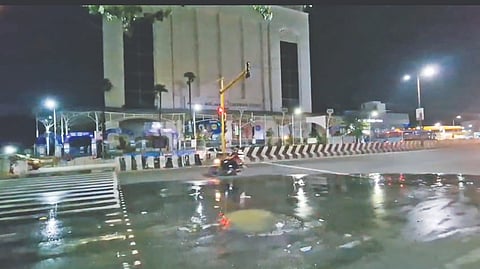A two-wheeler passing by a puddle of sewage water on the road along GST Road juncition in Chromeopet