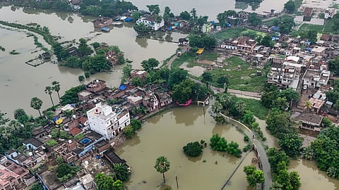 Children wade through floodwaters in an inundated area following a rise in the water level of Ganga river, in Patna, Sunday, Sept. 6, 2026