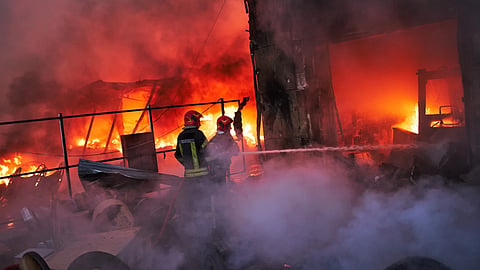 Firefighters try to extinguish a fire following a Russian missile attack in Kyiv, Ukraine