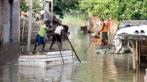 Villagers inspect repair work following a breach in the Mahi river dam after a rise in the water level, at Parsa in Saran district, Bihar