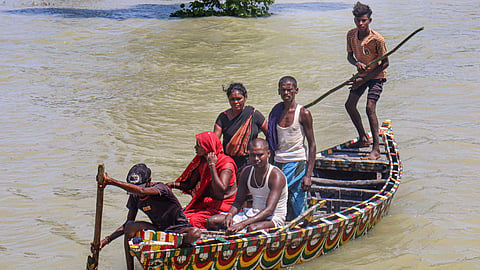 People cross the swollen Kosi river on a boat following the rise of water level, at Sadhupur village, in Purnia, Saturday, Sept. 12, 2026