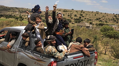 Yemeni civilians celebrate while riding in the back of a pickup truck in the Bani Matar district, Yemen, Saturday, Sept. 12, 2026, as they follow a convoy carrying Houthi prisoners freed in Mokha on its way to Sanaa following the Houthi takeover of the southern Red Sea port city.
