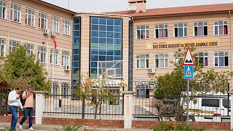 People walk past a vocational and technical high school in the Turgutlu district of Manisa province, western Turkey.