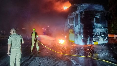 Firefighters at the site after a sleeper bus caught fire on the Yamuna Expressway in the Greater Noida area, killing nine passengers, in Noida