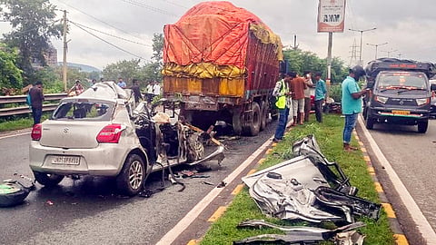 People gather at the site after a car rammed into a stationary truck, in Jamshedpur