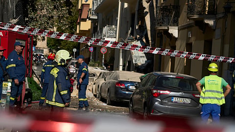 Firefighters work at the scene following a powerful blast that caused a building to collapse and injured at least two people in Athens' Plaka district