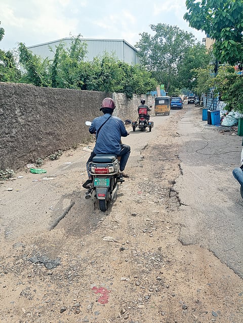 Vehicles navigate through potholes on EB Road in Perambur