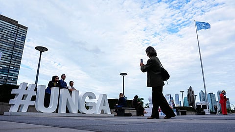People pose as they arrive for the United Nations General Assembly (UNGA) at the UN headquarters.