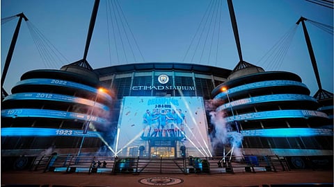 A banner celebrating their title win is illuminated outside Manchester City’s Etihad stadium in Manchester, England.