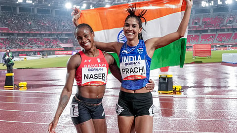 Bronze medallist India's Prachi Choudhary, right, celebrates with gold medallist Bahrain's Salwa Naser after the women's 400m final race during the 20th Asian Games