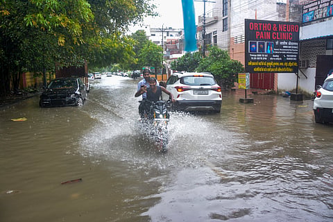  An auto-rickshaw moves through a waterlogged road amid rainfall, in Lucknow, Uttar Pradesh