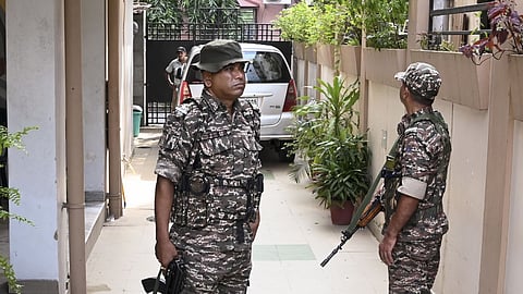 Security personnel stand guard as Enforcement Directorate (ED) officials conduct searches at the residence of former West Bengal minister Indranil Sen, in Kolkata, West Bengal.