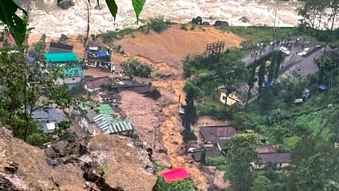 Mud and debris flow down through a residential area following a landslide triggered by continuous rainfall on late Thursday, at Rimbi village, in Yuksom-Tashiding