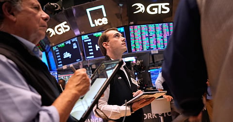 Traders work on the floor at the New York Stock Exchange in New York