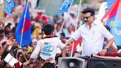 MK Stalin greets a child during a road show in Dharapuram

