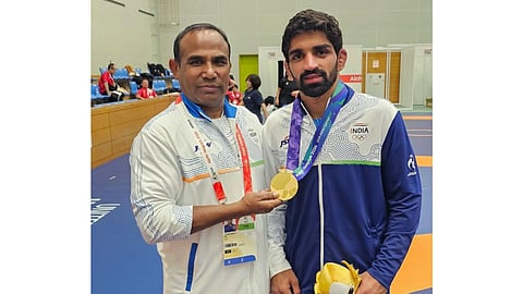 Aman Sehrawat, who won men's 57kg gold at the ongoing 20th Asian Games, with national freestyle coach Vinod Kumar, in Nagoya, Japan, Saturday, Oct. 3, 2026.
