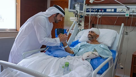 In this photo provided by the Government of Dubai Media Office, Dubai Crown Prince Sheikh Hamdan bin Mohammed bin Rashid Al Maktoum, left, visits injured Indian Flydubai Capt. Smit Machchhar at a hospital in Abu Dhabi, United Arab Emirates