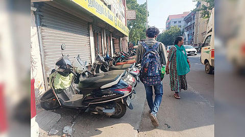 Two-wheelers on the walkway leave little to no space for pedestrians on Prakasam Road.