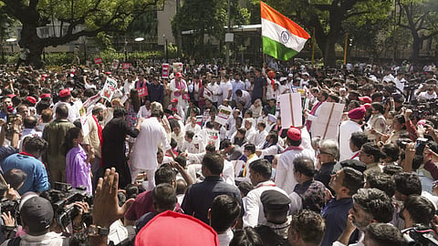 INDIA bloc leaders and supporters hold placards and wave the national flag while sitting on a dharna after being stopped by security forces during their protest march towards the Election Commission of India (ECI) office, demanding the resignation of Chief Election Commissioner Gyanesh Kumar, in New Delhi.