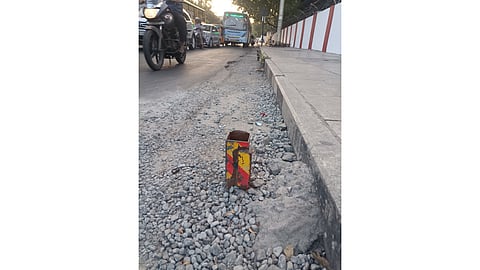 The pole sticking out of the road.