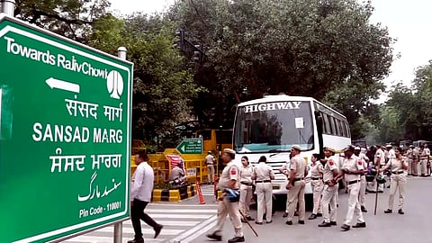 Security personnel stand guard as heavy police deployment and entry restrictions are enforced opposite the Jeevan Bharati Building at Connaught Place Outer Circle, in New Delhi