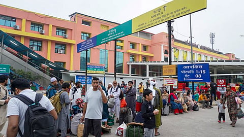 Passengers wait outside the New Delhi Railway Station amid heightened security arrangements following planned protests by the Cockroach Janta Party (CJP)