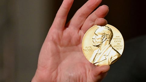 A Nobel medal is held up during a ceremony in New York.