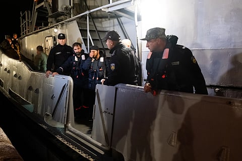 Four of the saved sailors from the drone-attacked and sunk ship HS Dignity seen on emergency rescue tug of Bulgarian Navy's - Mizar as they are transported to the port of Varna, Bulgaria, late Tuesday, Oct. 13, 2026.
