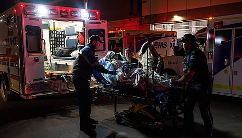 Paramedics load an injured person into an ambulance at the Wainwright Health center after a fire at Canadian Forces Base Wainwright, outside of Wainwright, Alberta