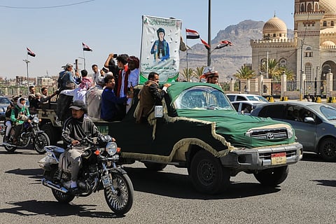 People ride in a pickup truck during a funeral procession for a Houthi officer in Sanaa, Yemen, Saturday, Oct. 17, 2026. The Arabic banner reads, “Martyr Mazen Abdallah.”