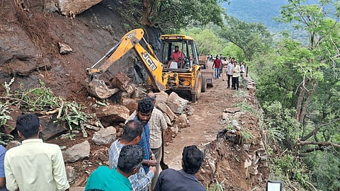 Workers clear boulders on the Pollachi–Valparai ghat road using an earthmover on Wednesday