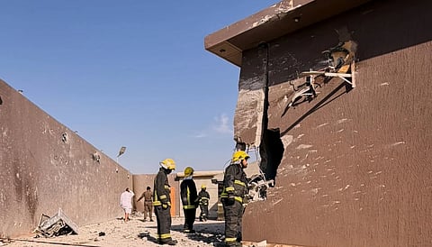 Firefighters inspecting damage to a building caused by falling debris from a drone