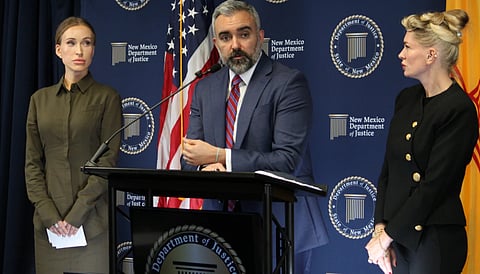 New Mexico Attorney General Raúl Torrez stands with Julia Molchanova, left, and Anouska De Georgiou, right, as he answers questions about a lawsuit against the co-executors of Jeffrey Epstein's estate during a news conference in Albuquerque