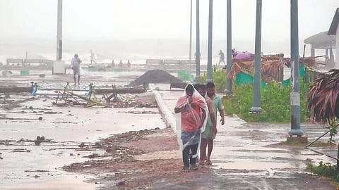 Residents brave winds and rainfall ahead of Cyclone Arnab’s landfall, at a coastal area in Kakinada, Andhra Pradesh, on Wednesday