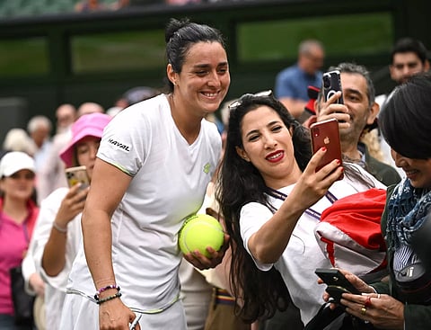 Ons Jabeur poses for a photograph with a spectator