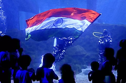 Scuba divers hold national flag under water at VGP Marine Kingdom, ahead of Independence Day on Monday
