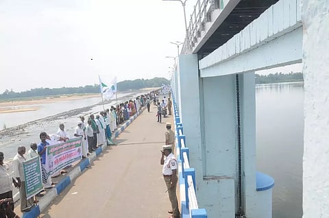 Farmers during a human chain protest on the Mukkombu regulator in Tiruchy on Thursday