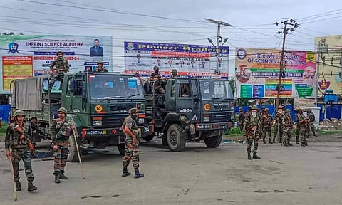 Security personnel stand guard at violence-hit Konung Mamang area during the ongoing ethnic clashes, in Imphal East district. (PTI)