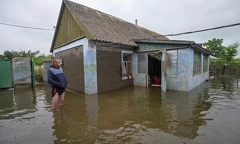Man standing in water in a marooned area impacted by the dam breach. Reuters